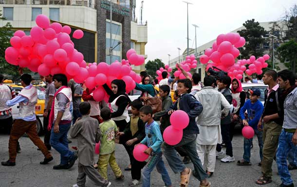 PROMOTING PEACE: Afghan volunteers distribute balloons to residents during the ‘We Believe In Balloons’ art project promoting peace in Kabul. — AFP photo