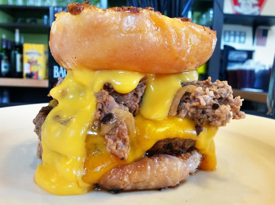 Burger heaven Beef patty cheddar cheese fried onions between a Donut
