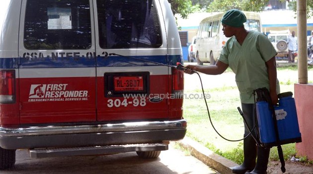 A medical worker disinfects an ambulance outside the John Fitzgerald Kennedy hospital in Monrovia on September 1, 2014/AFP