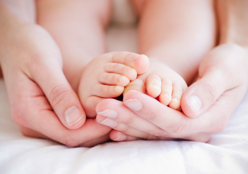 Mother holding baby's feet in hands, close-up