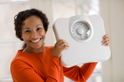 Beautiful African American woman holding scale
