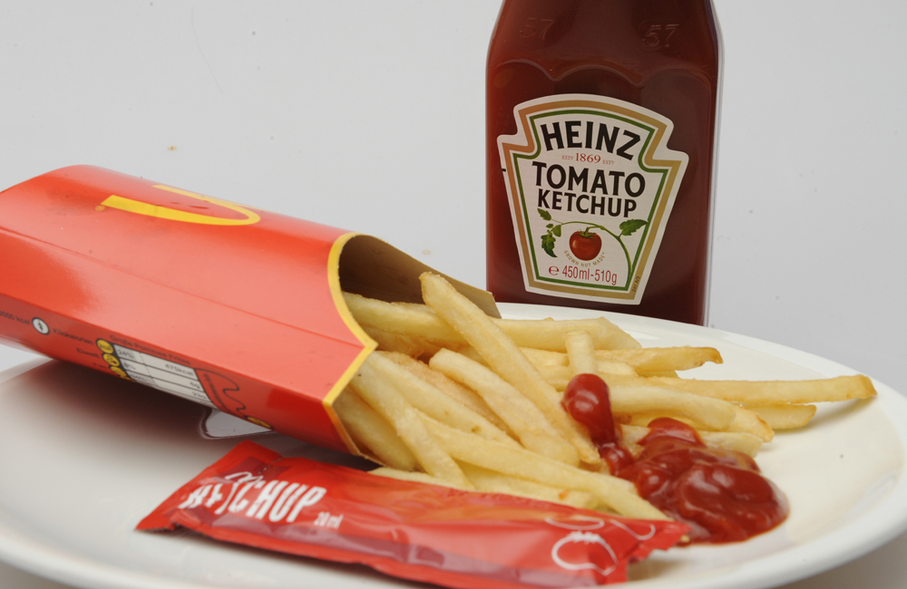 Pommes frites von McDonalds und Ketchup Tüte der Fa Develey Senf & Feinkost GmbH, München, die seit 1972 Mc Donald's in Deutschland beliefert. dahinter eine Flasche Heinz Tomato Ketchup. Foto: Horst Galuschka
