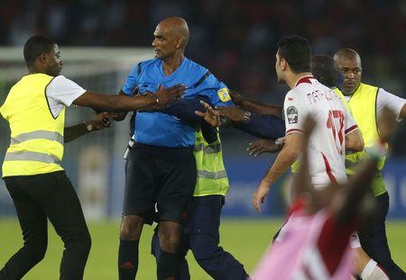 Referee Rajindraparsad Seechurn is surrounded by security as players of Tunisia confront him after losing their quarter-final soccer match of the 2015 African Cup of Nations against Equatorial Guinea in Bata