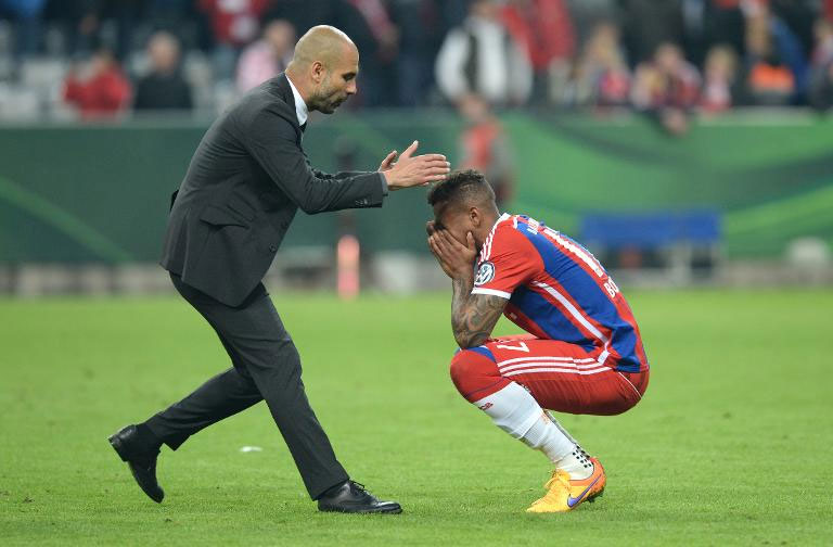 Bayern Munich coach, Pee Guardiola comforts defender Jerome Boateng (r) after crashing out of German Cup.