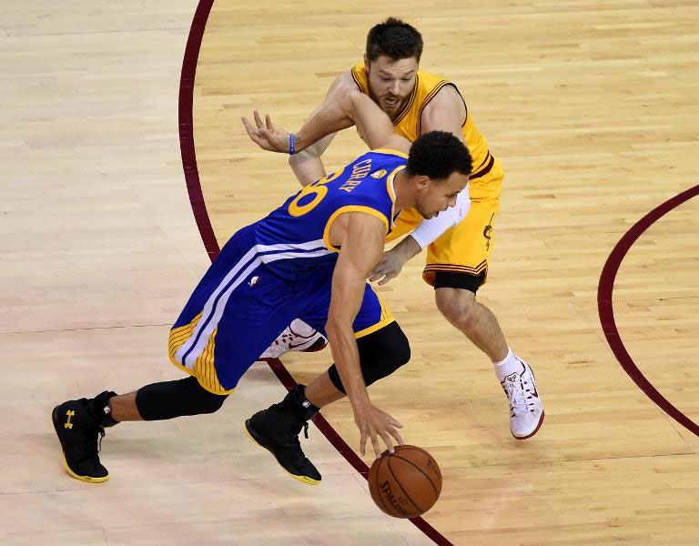 Cleveland Cavaliers' Matthew Dellavedova (top) defends against Golden State Warriors' Stephen Curry during Game 4 of the 2015 NBA Finals on June 11, 2015.