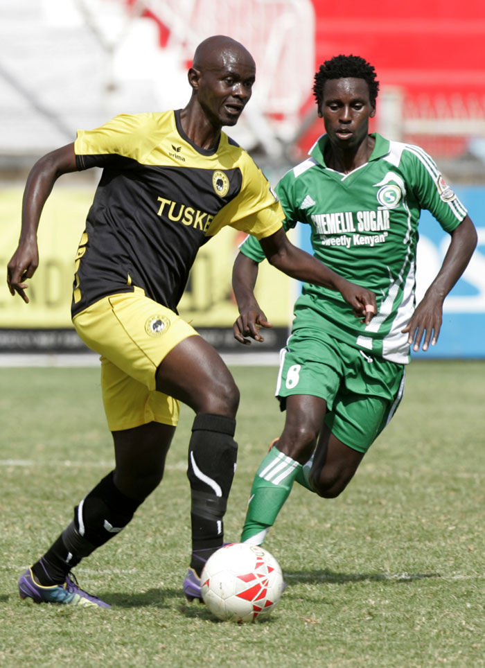 Tusker FC's Osborne Monday (left) in action in a SPL match against Chemelil. PHOTO/Raymond Makhaya