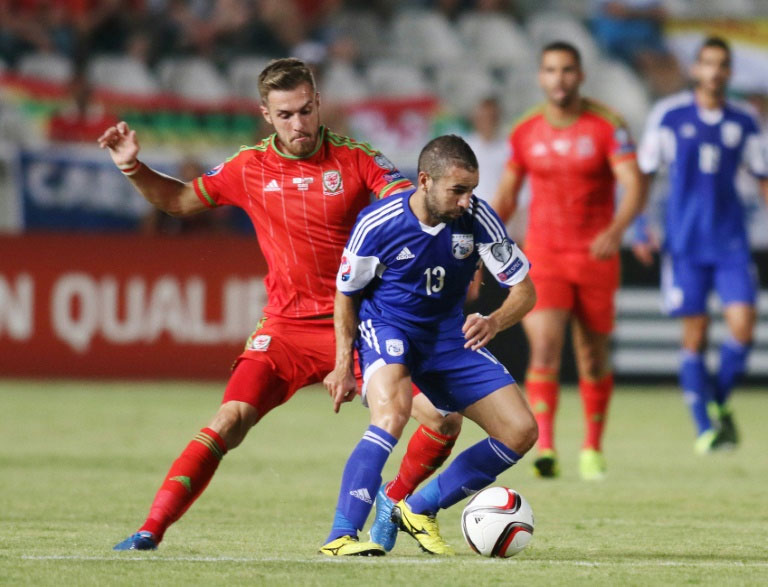 Cyprus' player Constantinos Charalambides (R) fights for the ball against Wales' player Aaron Ramsey during the EURO 2016 qualifying football match at the GSP stadium in the Cypriot capital Nicosia on September 3, 2015. PHOTO/AFP