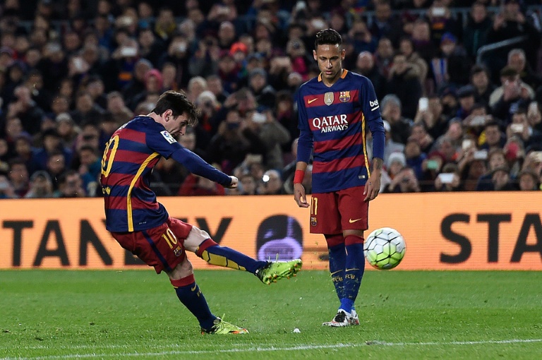 Barcelona's Lionel Messi (L) shoots a free kick to score a goal during the Spanish league football match FC Barcelona vs Sevilla FC at the Camp Nou stadium in Barcelona on February 28, 2016. PHOTO/AFP