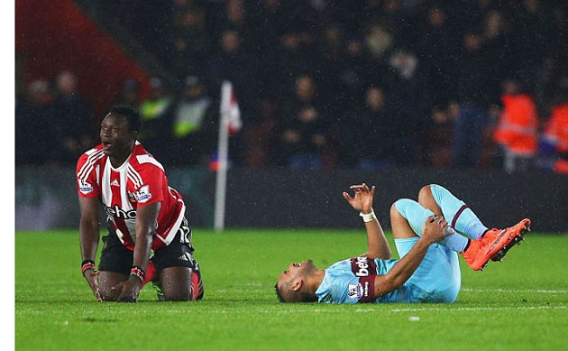 The West Ham midfielder writhes in agony as Wanyama gets up to learn his fate